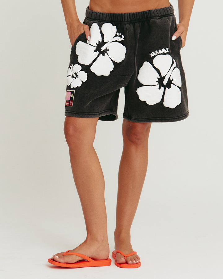 Person standing in photo studio wearing black Happy Hibiscus Shorts