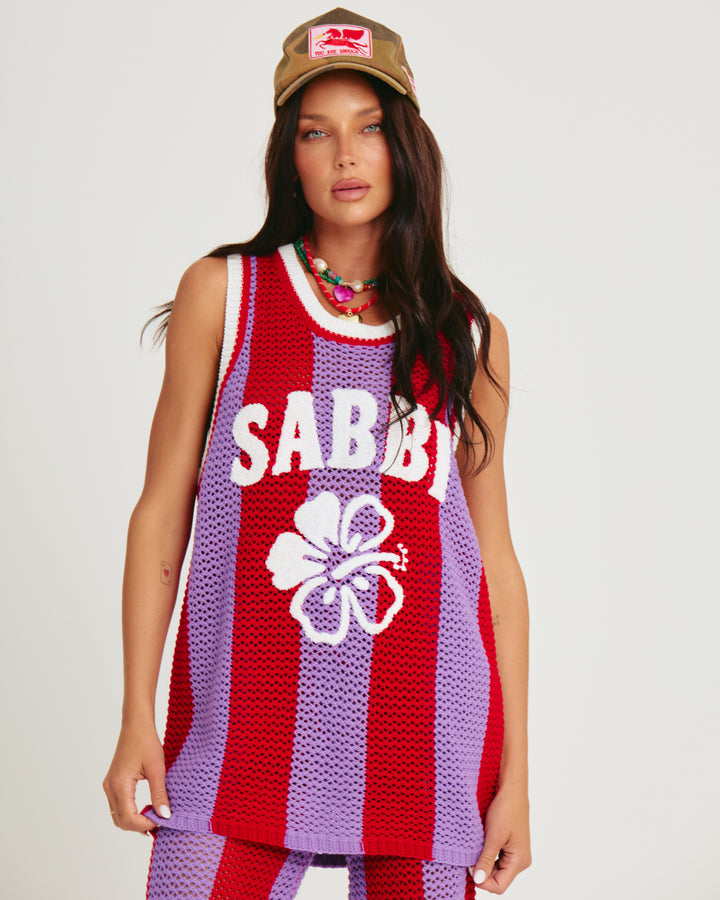 Person standing in photo studio wearing red and purple striped Knit B-Ball Singlet
