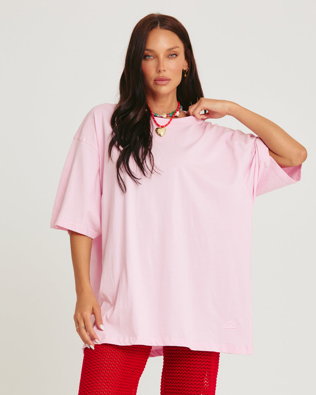Person standing in photo studio wearing light pink Very Oversized Basic Tee
