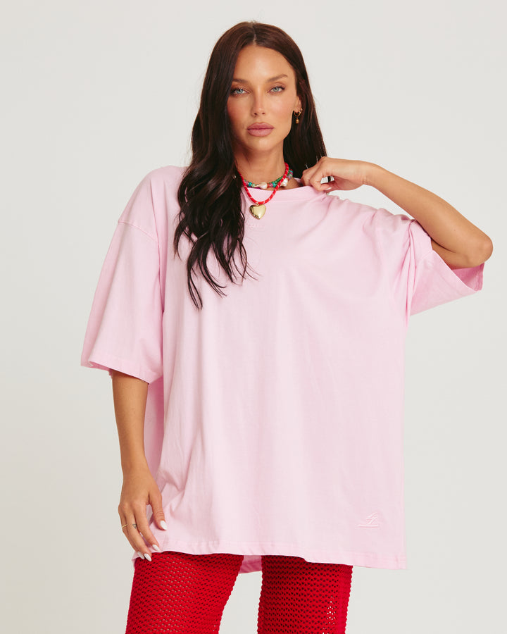Person standing in photo studio wearing light pink Very Oversized Basic Tee