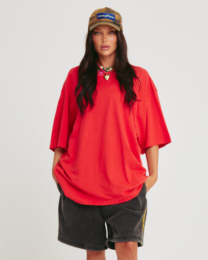 Person standing in photo studio wearing red Very Oversized Basic Tee