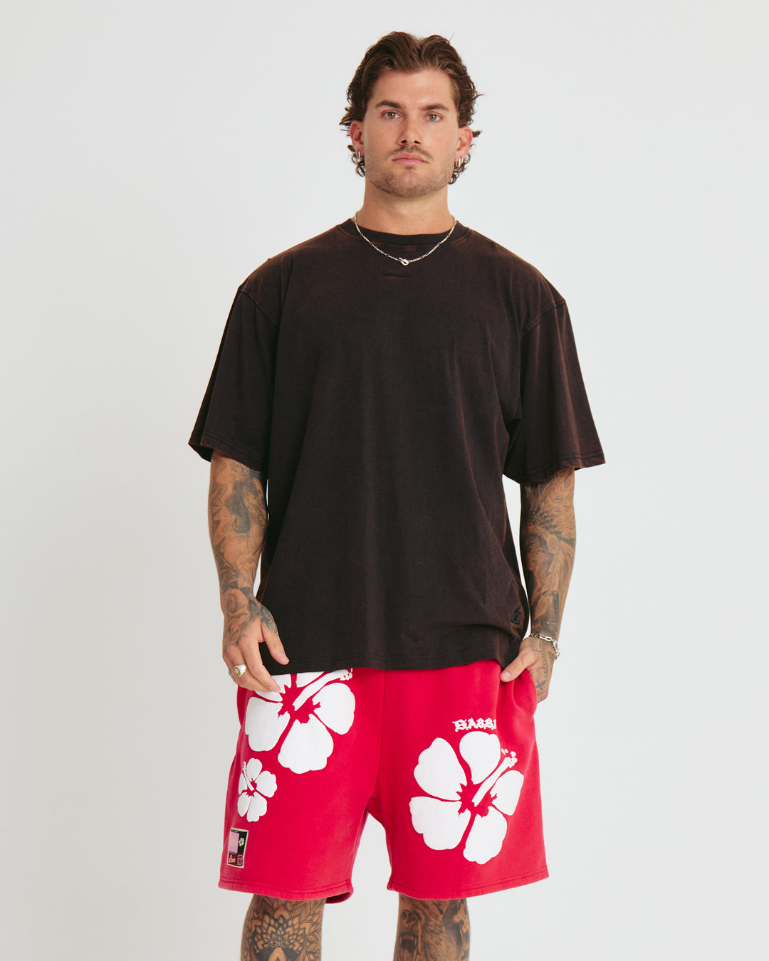 Person standing in photo studio wearing rust black Very Oversized Basic Tee