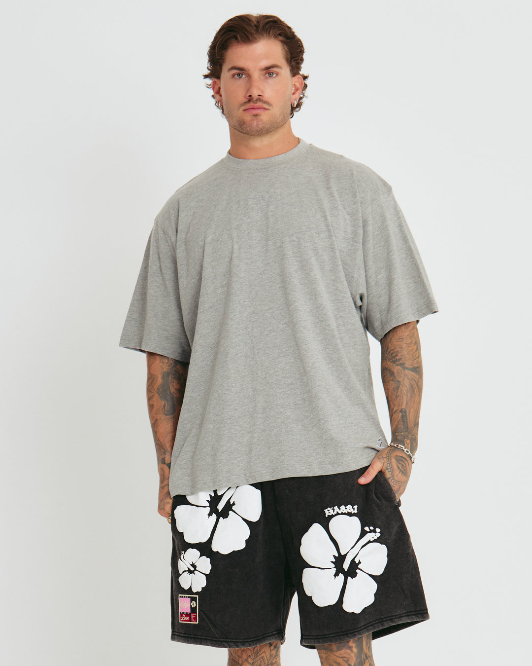 Person standing in photo studio wearing grey Very Oversized Basic Tee