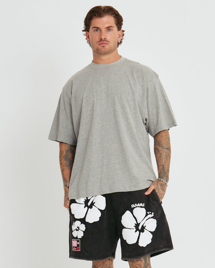 Person standing in photo studio wearing grey Very Oversized Basic Tee