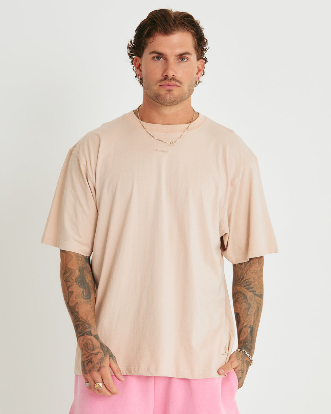 Person standing in photo studio wearing stone Very Oversized Basic Tee