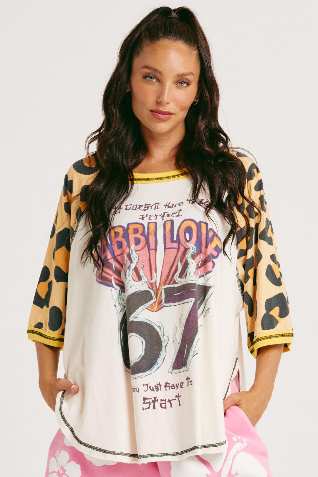 Woman wearing a leopard print sleeve raglan tee with SABBI LOVE 67 in bright lettering 